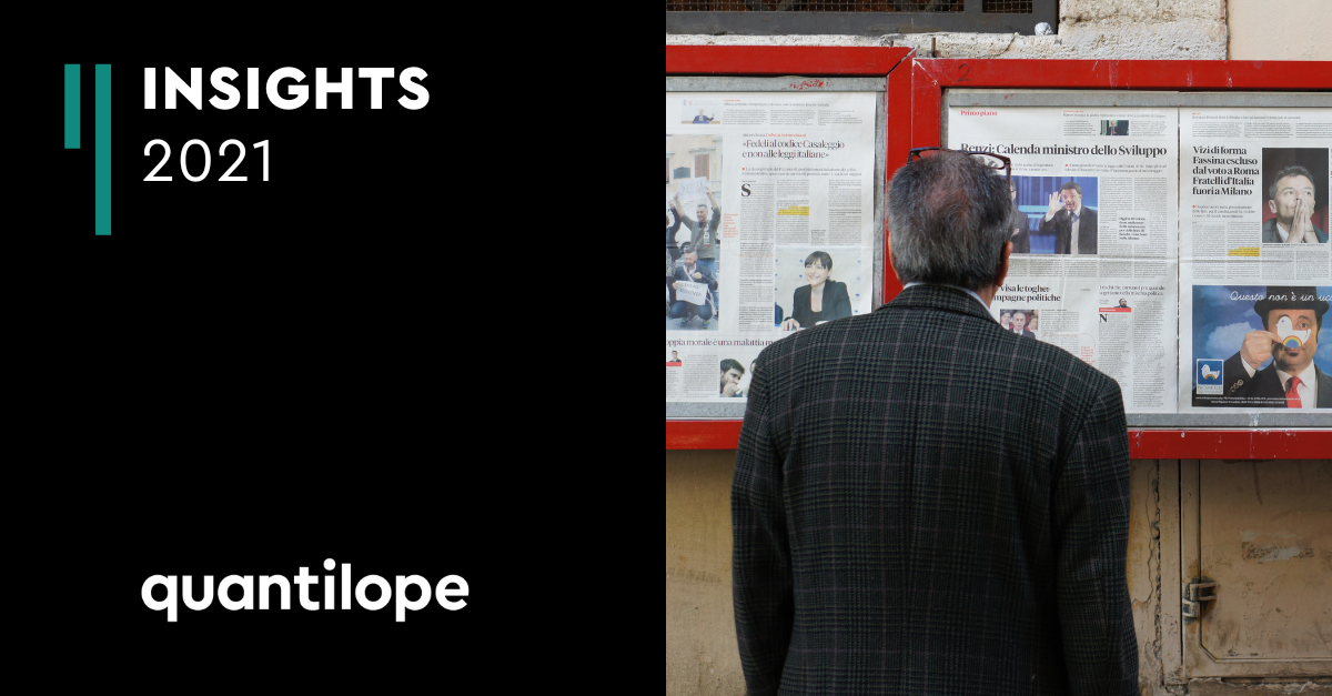 Man looking at several newspapers 